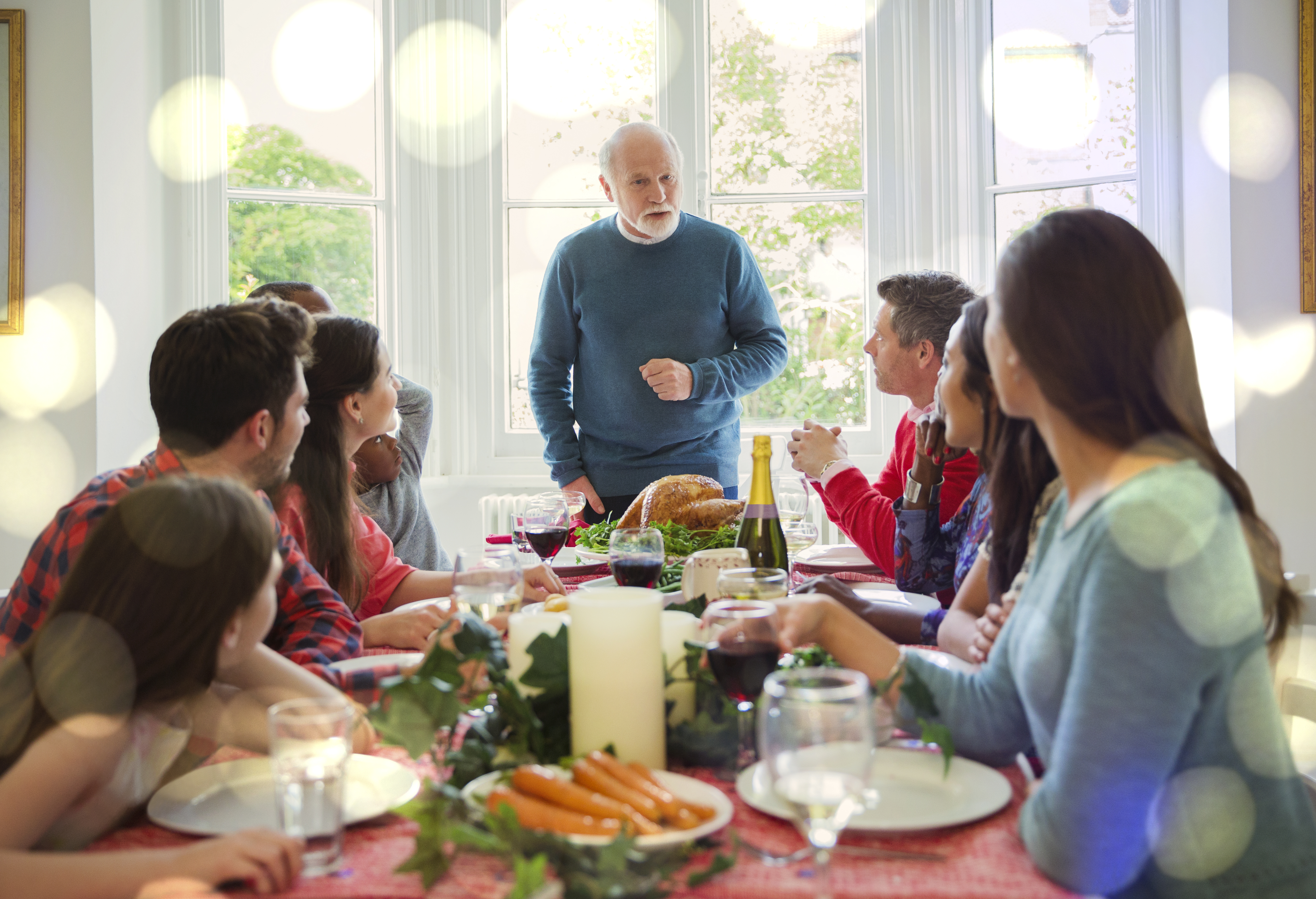 Grandfather preparing to carve Christmas turkey at dinner table