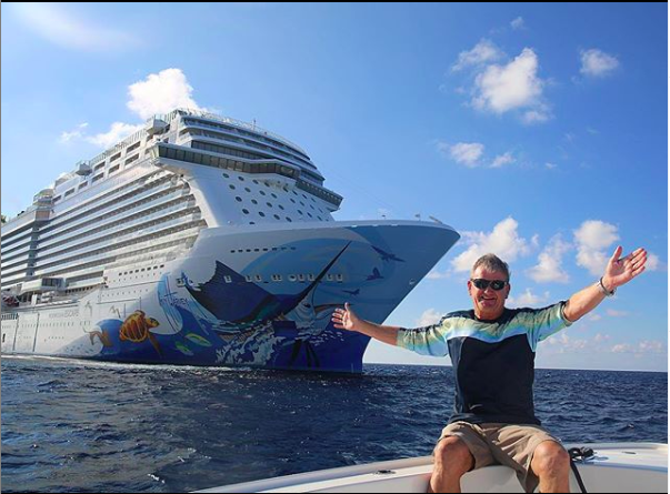 Guy Harvey in front of a cruise ship decorated with his artwork.