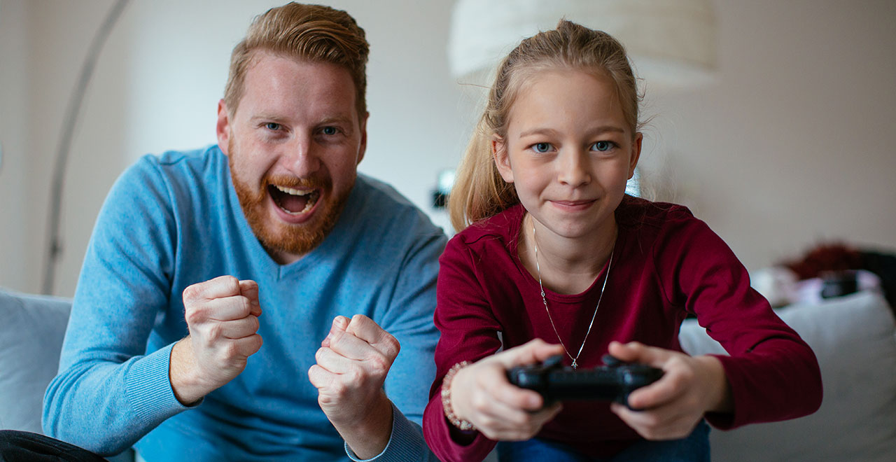 dad playing video game with daughter