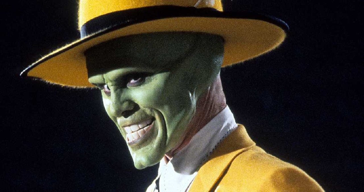 Carrey grinning maniacally with a yellow fedora and behind his iconic green mask