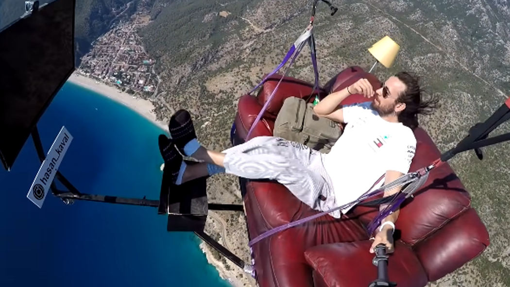 Man Paraglides While Sitting on the Sofa Watching TV