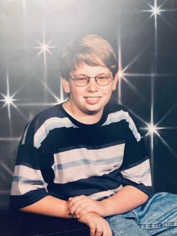 Awkward School Pic of kid with glasses in front of a digital star field