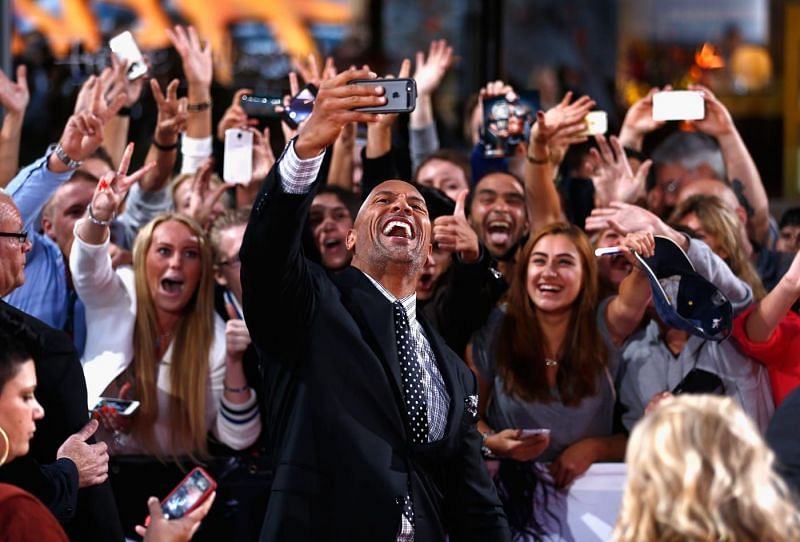 The Rock takes selfies with fans on the red carpet.